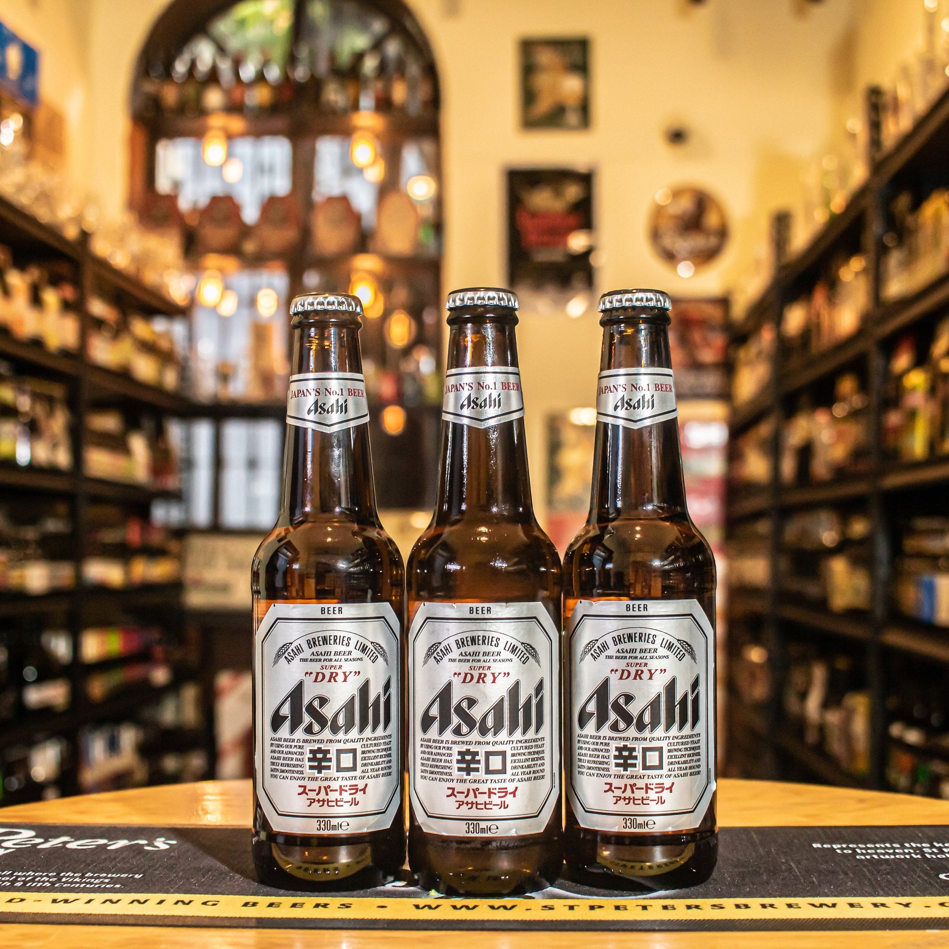 Botella de Asahi Super Dry, una Japanese Rice Lager de Asahi Breweries, Japón. La etiqueta tiene un diseño clásico y elegante. Con un ABV de 5%, presenta aromas sutiles de grano, lúpulo fresco y un toque de arroz. Su sabor es limpio y crujiente, con un amargor moderado y un final seco. Ideal para maridar con sushi, tempura, mariscos y platos ligeros. Una cerveza refrescante y equilibrada, perfecta para acompañar la cocina asiática.