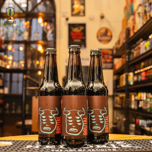 Botella de Brutal Imperial Stout, una Imperial Stout de Border Psycho Brewery, elaborada en Tijuana, Baja California. La etiqueta presenta un diseño oscuro y robusto que refleja su intensidad. Con un ABV de 10.5%, ofrece aromas de maltas tostadas, chocolate y un toque de anís. Su cuerpo completo y suave, con un final cálido, la hacen ideal para acompañar postres de chocolate, carnes rojas asadas o disfrutarla como cerveza de sobremesa. Su diseño transmite poder y riqueza en sabores.