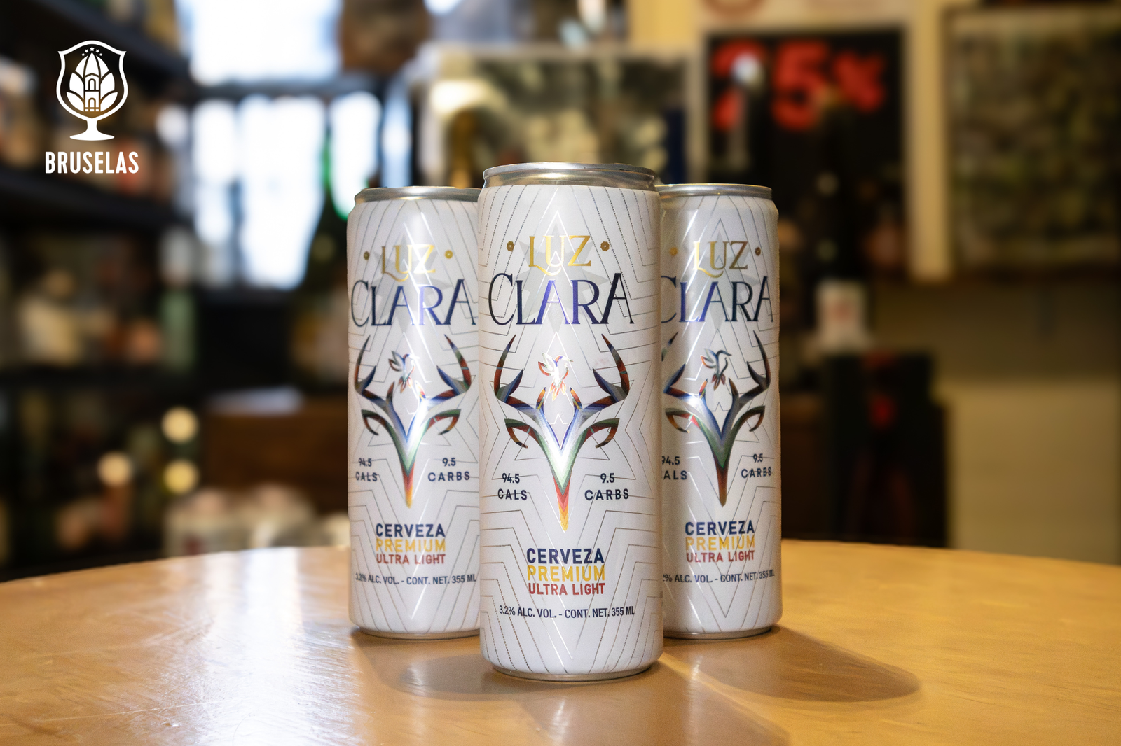 Tres cervezas en presentación de lata de la marca Luz Clara de Villa castel, sobre una mesa de madera
