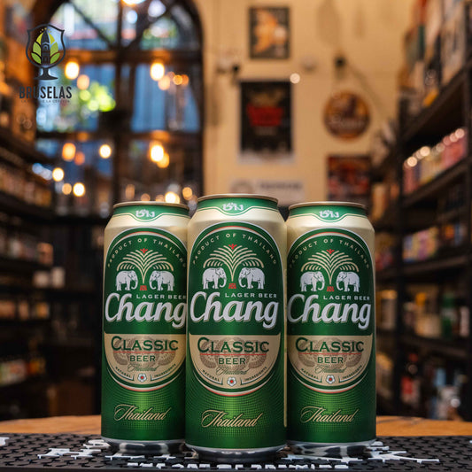 Lata de Chang, una lager tailandesa elaborada por ThaiBev. Con un ABV de 5.0%, esta cerveza tiene un perfil refrescante y bien equilibrado, con notas ligeras de malta y un moderado amargor. Su aroma incluye toques herbales que complementan su suavidad. Ideal para acompañar comida tailandesa, mariscos y ensaladas frescas, esta cerveza ligera es perfecta para disfrutar en cualquier ocasión. Presentación en lata de 500 ml