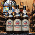 Botella de Erdinger Weissbier, una reconocida cerveza de trigo elaborada por Erdinger Weissbräu en Baviera, Alemania. Con un ABV de 5.3%, esta Weissbier se caracteriza por su color dorado turbio y espuma densa. Ofrece aromas a plátano, clavo y vainilla, mientras que su sabor es suave, frutal y ligeramente especiado, con un final refrescante. Ideal para maridar con platos de pescado, ensaladas ligeras y quesos suaves. Presentación en botella de 500 ml.