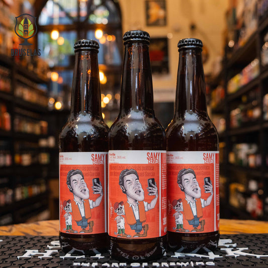 Botella de Error de Diciembre Sammy, una Pale Ale mexicana de 5% ABV elaborada por la cervecería Error de Diciembre. La etiqueta roja muestra una caricatura satírica de un personaje político mexicano, reflejando el estilo humorístico de la marca. Con notas cítricas y un amargor moderado, esta cerveza refrescante es ideal para maridar con tacos, hamburguesas y botanas.