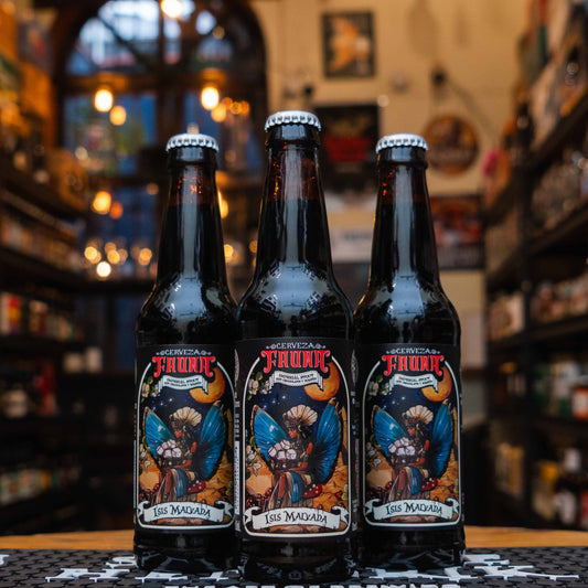 Botella de Isis Malvada de Cervecería Fauna, una Imperial Stout mexicana con 8% ABV. Su etiqueta tiene un diseño artístico que muestra una figura mitológica con alas, bajo un fondo oscuro y detalles vibrantes. Enriquecida con bombones, ofrece notas de chocolate, café tostado y vainilla. Ideal para maridar con postres de chocolate, quesos fuertes y carnes asadas. Robusta y única.