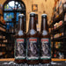 Botella de Fauna Little Hazy, una Session IPA de Cervecería Fauna, elaborada en Baja California. La etiqueta muestra un lobo aullando con detalles oscuros y místicos. Con un ABV de 5.5%, ofrece aromas de mango y piña, con un cuerpo ligero y poco amargor. Ideal para acompañar comidas ligeras y picoteos. El diseño refleja su carácter refrescante y frutal.