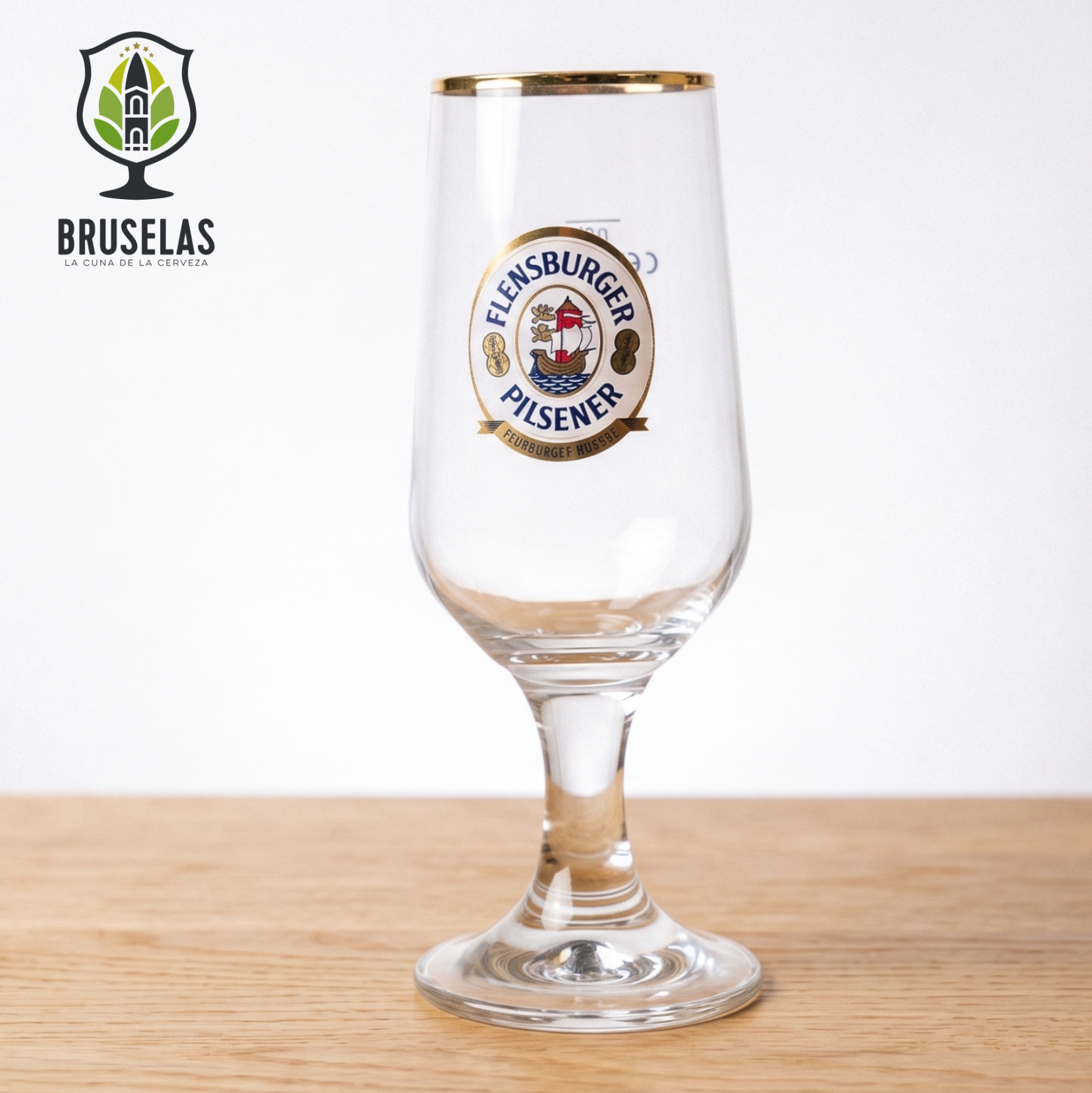 Copa oficial Flensburger Pilsener de estilo Pokal con tallo y capacidad de 300 ml.
Fabricada por Ritzenhoff, destaca por su inconfundible logotipo a todo color y un elegante borde dorado.