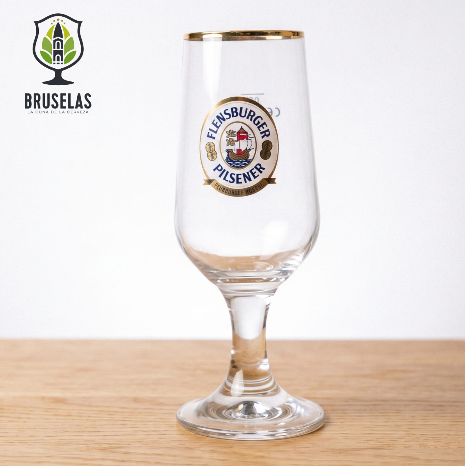 Copa oficial Flensburger Pilsener de estilo Pokal con tallo y capacidad de 300 ml.
Fabricada por Ritzenhoff, destaca por su inconfundible logotipo a todo color y un elegante borde dorado.