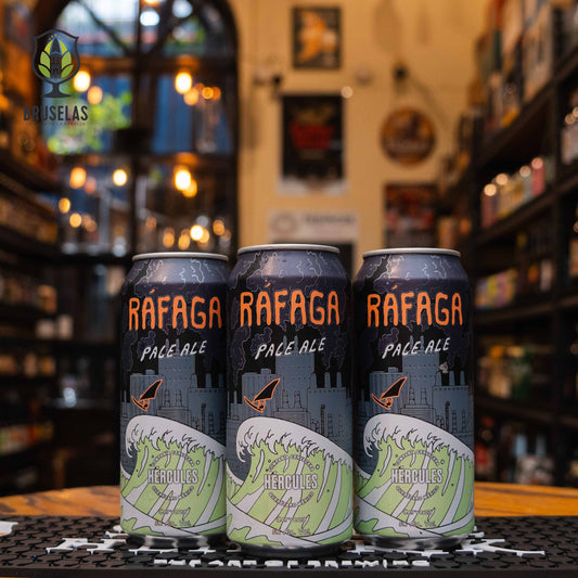 Lata de Ráfaga, una American Pale Ale de Compañía Cervecera Hércules con un ABV de 5%. La etiqueta presenta ilustraciones de una gran ola y una fábrica, con tonos verde y azul. Esta cerveza destaca por su amargor moderado y notas cítricas y tropicales, ideal para maridar con tacos, pescados a la parrilla o ensaladas. Perfecta para días cálidos.