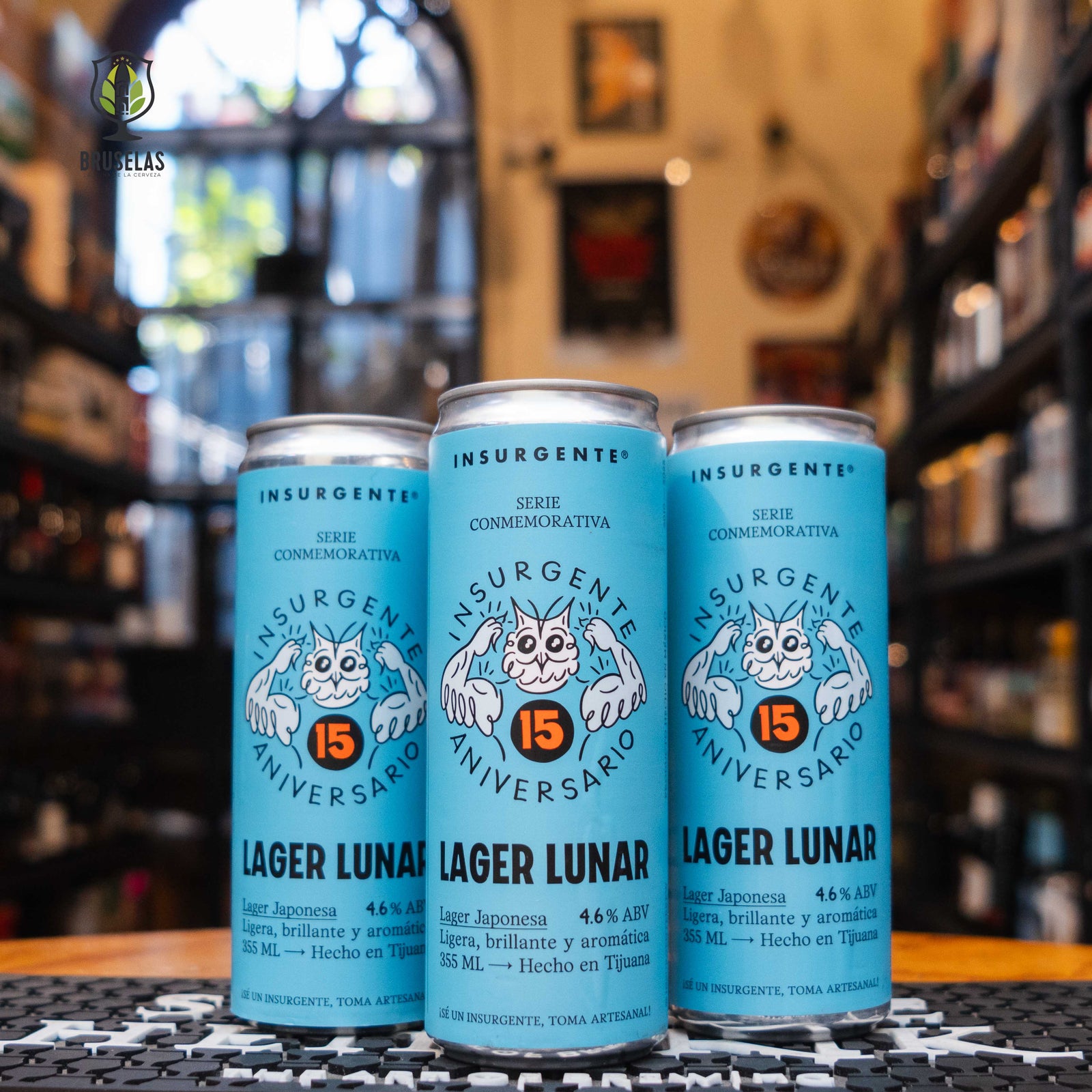 Insurgente Lager Lunar en su presentación conmemorativa por el 15 aniversario, con diseño azul celeste y un personaje lunar ilustrado. Lager japonesa brillante y refrescante, perfecta para acompañar platos ligeros o refrescarte en cualquier momento.