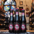 Botella de Tarot Noir de Lindemans, una Lambic Fruit belga con un ABV de 8%. La etiqueta presenta un diseño oscuro y místico, con la imagen de una mujer en tonos rosados y púrpura, evocando el arte del tarot. Esta cerveza, con sabor a bayas negras, equilibra dulzura y acidez. Ideal para maridar con carnes rojas o postres de chocolate. El diseño refleja su carácter misterioso y afrutado.