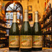 Botella de Lindemans Pecheresse, una Lambic Fruit belga de la cervecería Lindemans, ubicada en Pajottenland. Con un ABV de 2.5%, tiene un color dorado y burbujeo fino. Elaborada con jugo de durazno, ofrece aromas frutales con notas dominantes de durazno fresco. Su sabor es dulce, afrutado y ligeramente ácido. Ideal para maridar con ensaladas frescas, platos de cerdo, quesos suaves y postres de frutas.