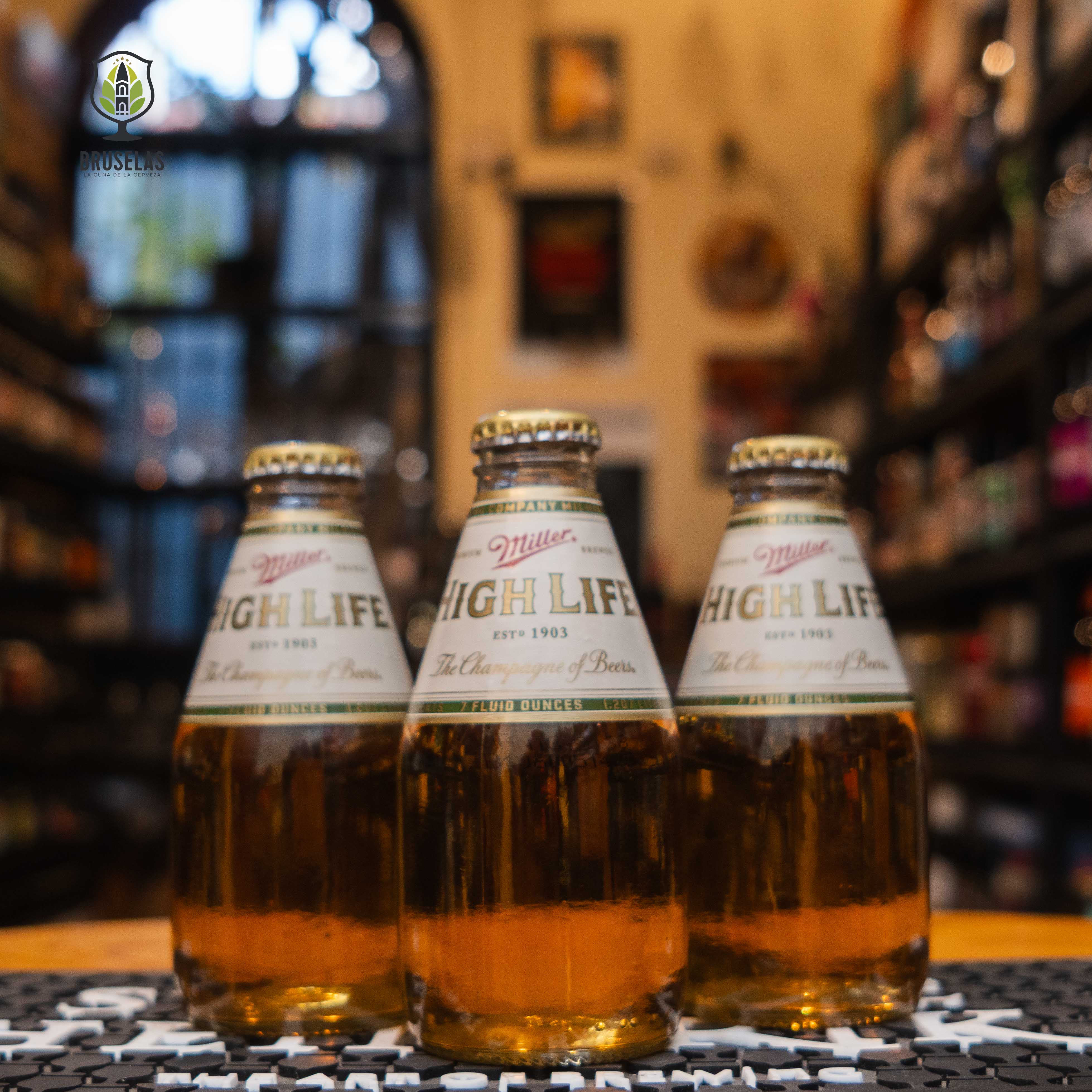 Botellas de Miller High Life Pony en una tienda de cerveza artesanal. Esta American Lager en presentación mini de 200 ml ofrece un perfil ligero y refrescante, perfecta para maridar con hamburguesas, pizza y snacks salados. ¡Disfrútala bien fría!