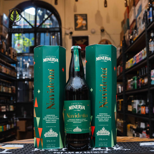 Botella de Minerva Navideña Doble Stout, una stout de 9% ABV elaborada por Cervecería Minerva en México. Presentada en caja verde con detalles dorados y decorativos. Hecha con Chocolate Ibarra, ofrece aromas de café, chocolate y canela, con un sabor robusto y equilibrado. Ideal para acompañar romeritos, pavo y postres de chocolate. Edición especial navideña con un diseño festivo y tradicional.