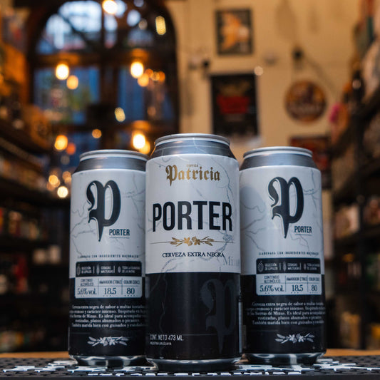 Lata de Patricia Porter, una cerveza uruguaya estilo Porter con 5.6% ABV. Su diseño combina tonos grises y negros con un logotipo elegante. Ofrece un perfil de maltas tostadas con notas de chocolate, café y caramelo, complementado por un amargor suave. Ideal para maridar con guisos, carnes asadas y postres de chocolate. Refleja la tradición cervecera de Uruguay con un carácter robusto y complejo.