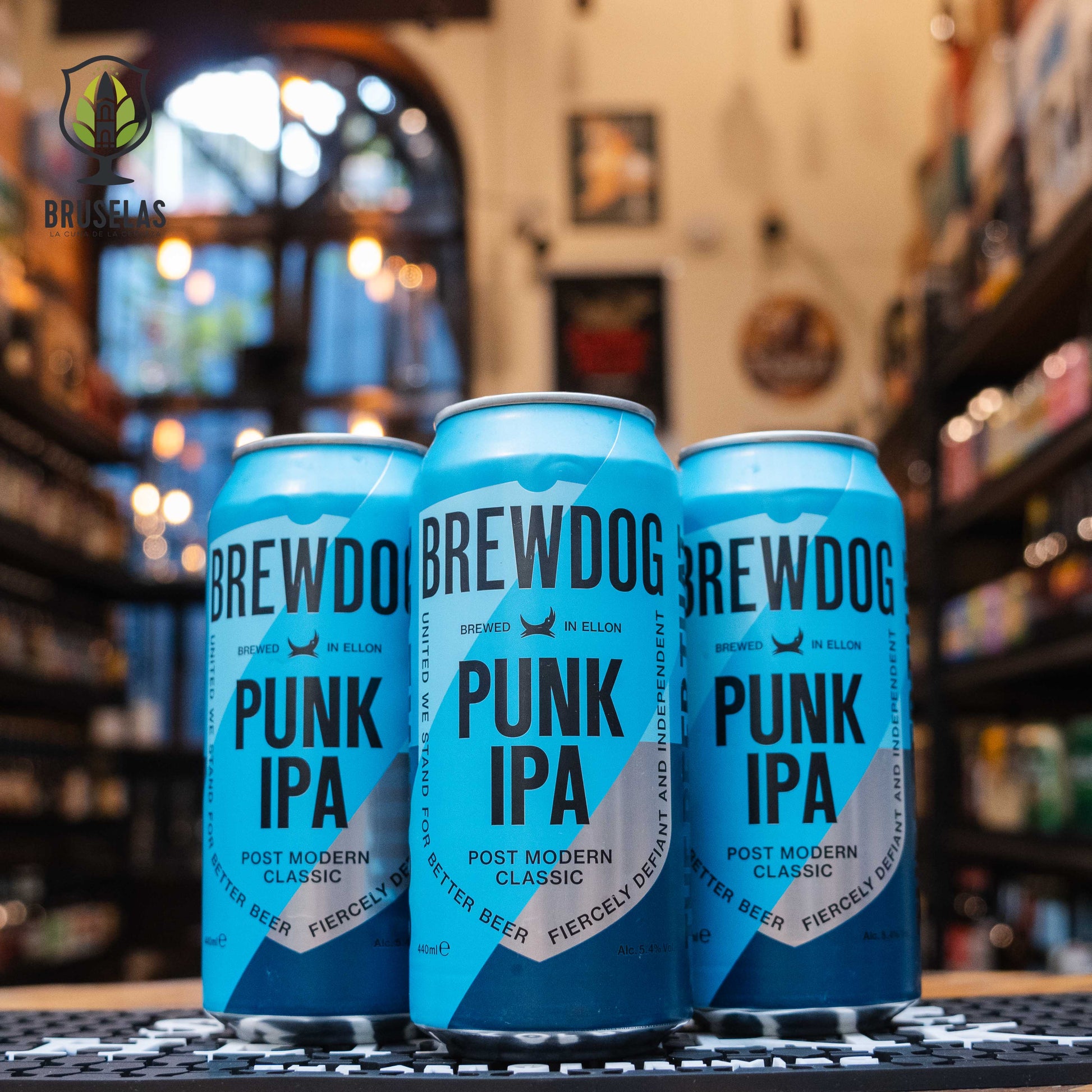 Lata de BrewDog Punk IPA, una cerveza estilo IPA elaborada por BrewDog en Ellon, Escocia. La lata presenta un diseño moderno en tonos azules con el nombre "Punk IPA" en letras grandes y negras. Presenta un ABV de 5.4% y un amargor moderado con 40 IBU, destacando sabores frutales tropicales y un final amargo persistente. Ideal para acompañar hamburguesas, parrilladas y comidas picantes.