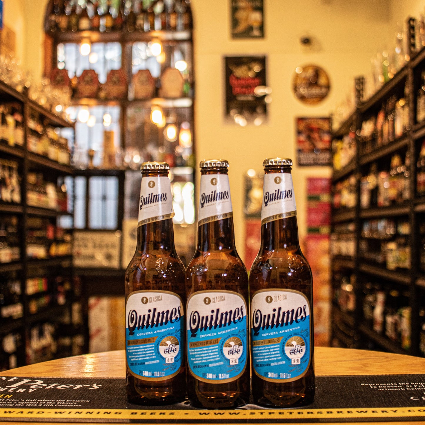 Botella de Quilmes, la Pale Lager más emblemática de Argentina, con un ABV de 4.9%. Presenta aromas suaves de malta y toques herbales. Su sabor es refrescante y balanceado, con un final limpio y seco, acompañado de un amargor sutil. Ideal para maridar con carnes a la parrilla, pizzas y quesos suaves. Quilmes es un símbolo de la cultura cervecera argentina desde 1888, perfecta para cualquier ocasión.