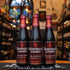 Botella de Rodenbach Alexander, una Flanders Red Ale de Brouwerij Rodenbach, Bélgica. La etiqueta presenta un fondo rojo Botella de Rodenbach Alexander, una Flanders Red Ale de Brouwerij Rodenbach, Bélgica. La etiqueta presenta un fondo rojo oscuro con una 'R' en grande y letras blancas. ABV de 5.6%, con aromas y sabores de cerezas ácidas, madera y un toque de vainilla. Ideal para acompañar quesos de cabra o azul, carnes a la parrilla y postres de chocolate. El diseño refleja la tradición belga en cervezas 