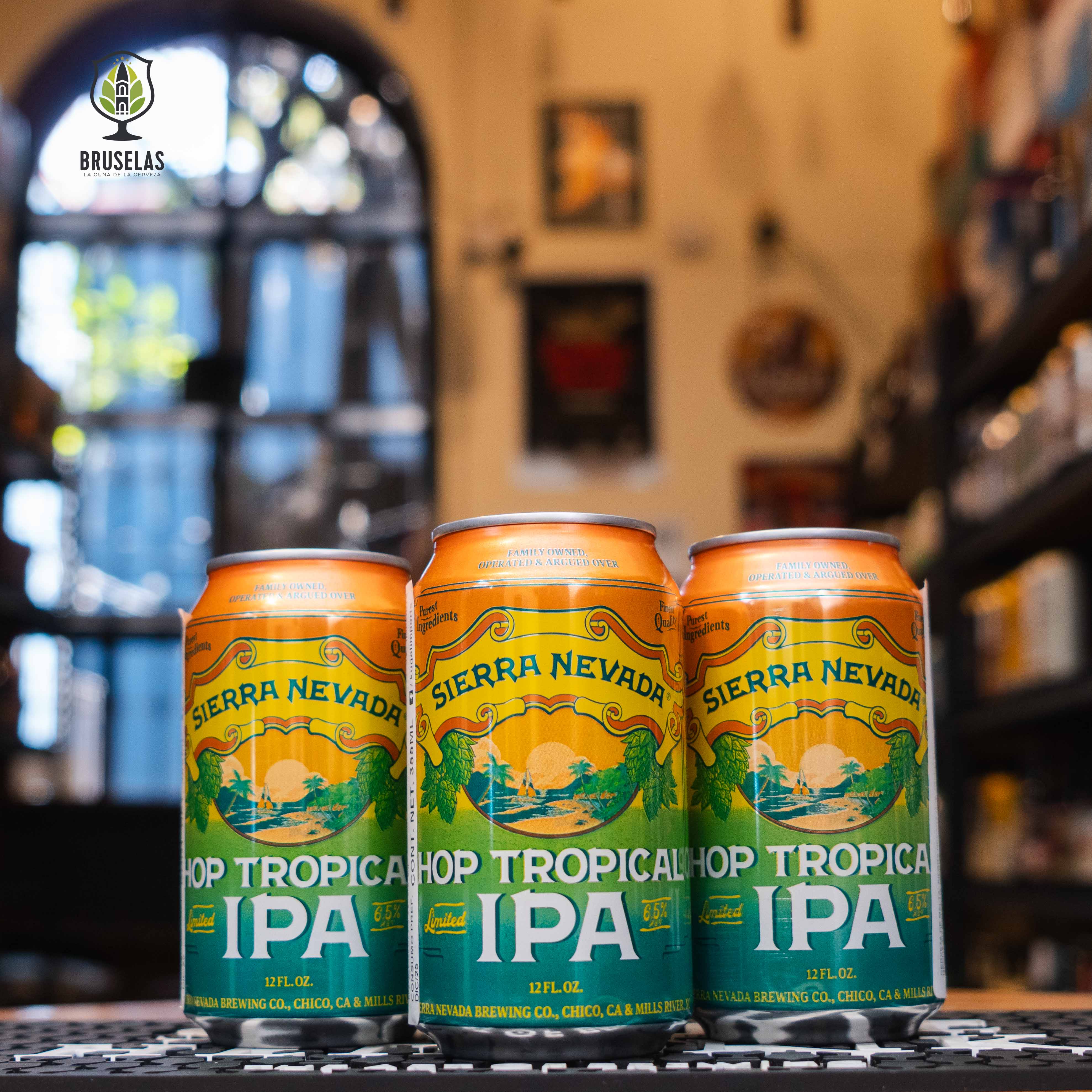  "Sierra Nevada Hop Tropical IPA" en primer plano con diseño colorido y vibrante, evocando paisajes tropicales que resaltan el carácter frutal y refrescante de esta cerveza americana.
