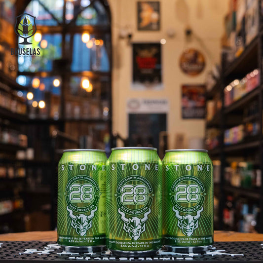 Lata de Stone 28th Anniversary Hazy Double IPA, una cerveza de estilo Hazy Double IPA de Stone Brewing, elaborada en EE.UU. La etiqueta es verde con un logotipo del aniversario en blanco y una gárgola al centro. Con un ABV de 8.5%, presenta intensos sabores tropicales como mango, piña y un toque herbal resinoso. Ideal para maridar con carnes a la parrilla, tacos de cerdo y postres cítricos. El diseño celebra los 28 años de la cervecería.