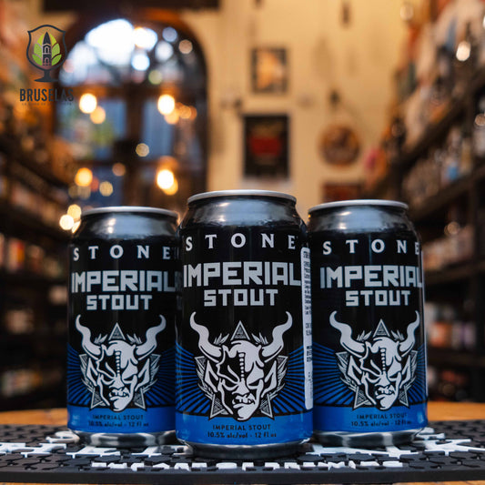 Lata de Stone Imperial Stout, una cerveza estilo Imperial Stout de Stone Brewing con 10.5% ABV. Su diseño negro y azul presenta un icónico logotipo de gárgola. Destaca por sus sabores a chocolate oscuro, café tostado y un toque de melaza, con un cuerpo denso y textura cremosa. Ideal para maridar con postres de chocolate, quesos intensos y carnes asadas. Potente y llena de carácter.