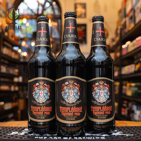 Botella de Templářské Tajemné Pivo Dark, una lager oscura checa de Pivovar Nova Paka. La etiqueta es negra con un escudo templario y detalles dorados, con el nombre en tipografía roja gótica. ABV de 4.6%. Sabor a malta tostada, caramelo y café. Ideal para acompañar carnes asadas y quesos fuertes. El diseño evoca un estilo medieval con un toque clásico.