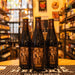 Botella de Vidar, una Braggot elaborada por Cervecería del Llano. Con un ABV de 7.0%, esta cerveza híbrida mezcla lo mejor de la hidromiel y las cervezas ale. Destaca por sus aromas a miel, maltas tostadas y toques florales. En boca, ofrece sabores de chocolate, café y miel, con un final suave y dulce. Ideal para acompañar postres de chocolate, quesos suaves y frutos secos. Es perfecta para quienes buscan explorar sabores únicos en cervezas artesanales.