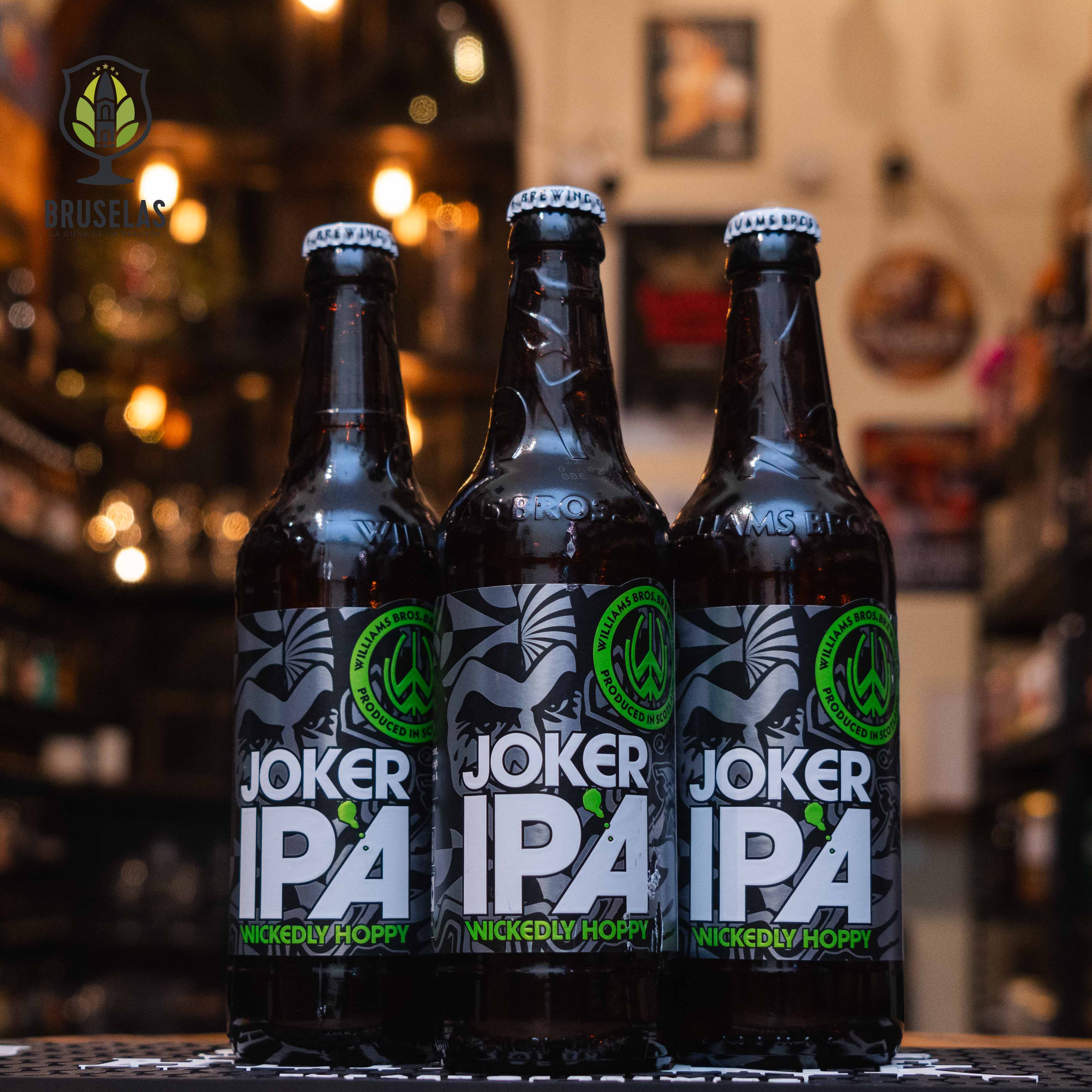 Botella de Williams Bros Joker IPA, una India Pale Ale escocesa con 5% ABV, elaborada por Williams Bros Brewing Co. Su etiqueta negra y gris presenta detalles llamativos con un logotipo verde vibrante. Ofrece notas cítricas, florales y un ligero toque de caramelo, con un amargor moderado y un final seco. Ideal para maridar con platos especiados, ensaladas frescas y botanas saladas. Refrescante y bien equilibrada.