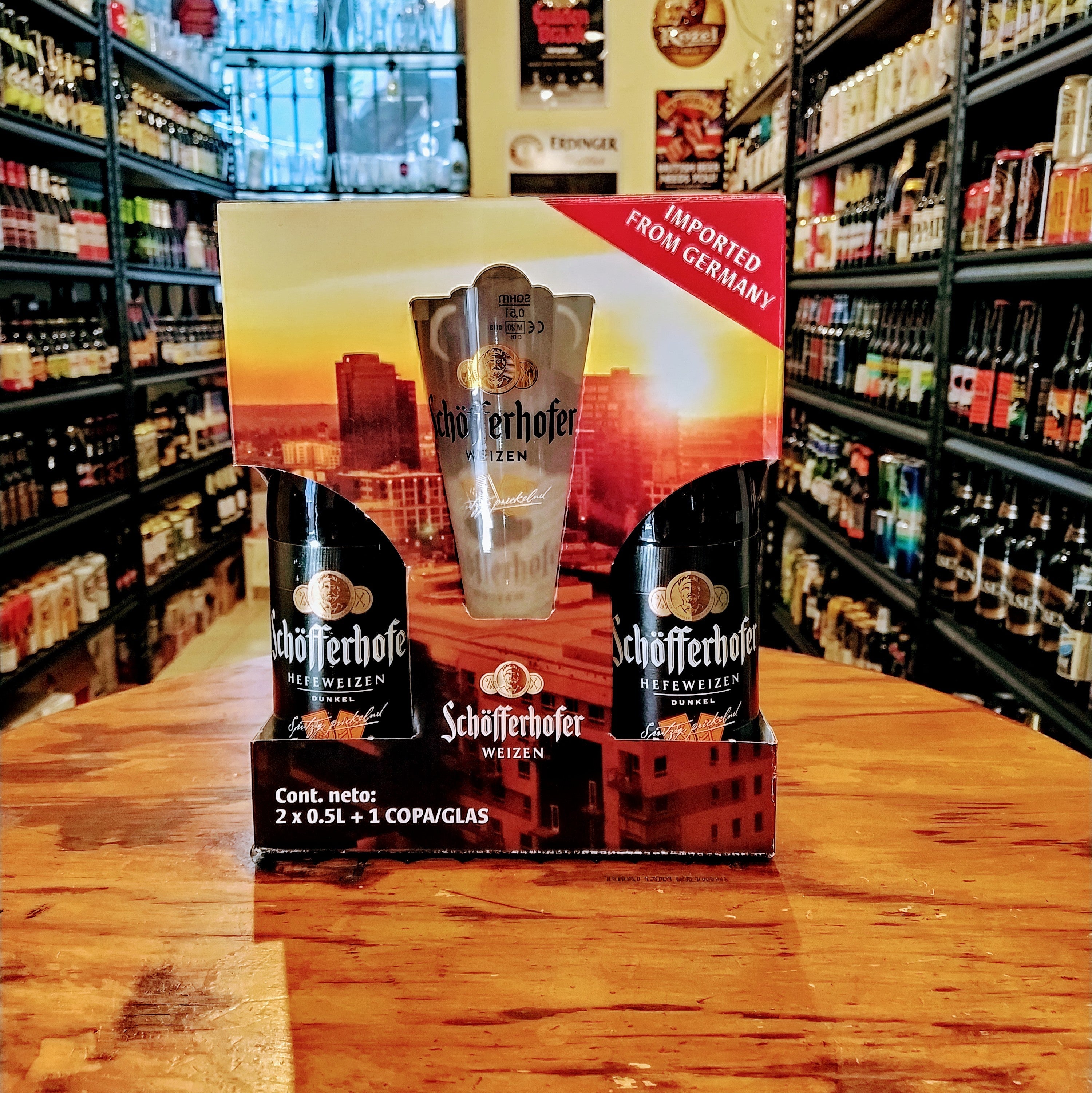 Giftpack Schöfferhofer con 2 botellas de 500 ml (Hefeweizen y Dunkel) y pinta oficial, sobre fondo de tienda cervecera artesanal